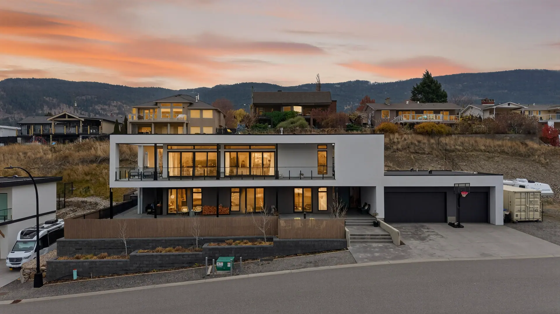 Twilight aerial of a modern Lake Country home with the lights on