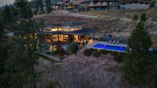 Aerial view twilight pool, luxury lake-view home in Lakestone, Lake Country, BC. Real estate photography by Pixel Pro Productions.
